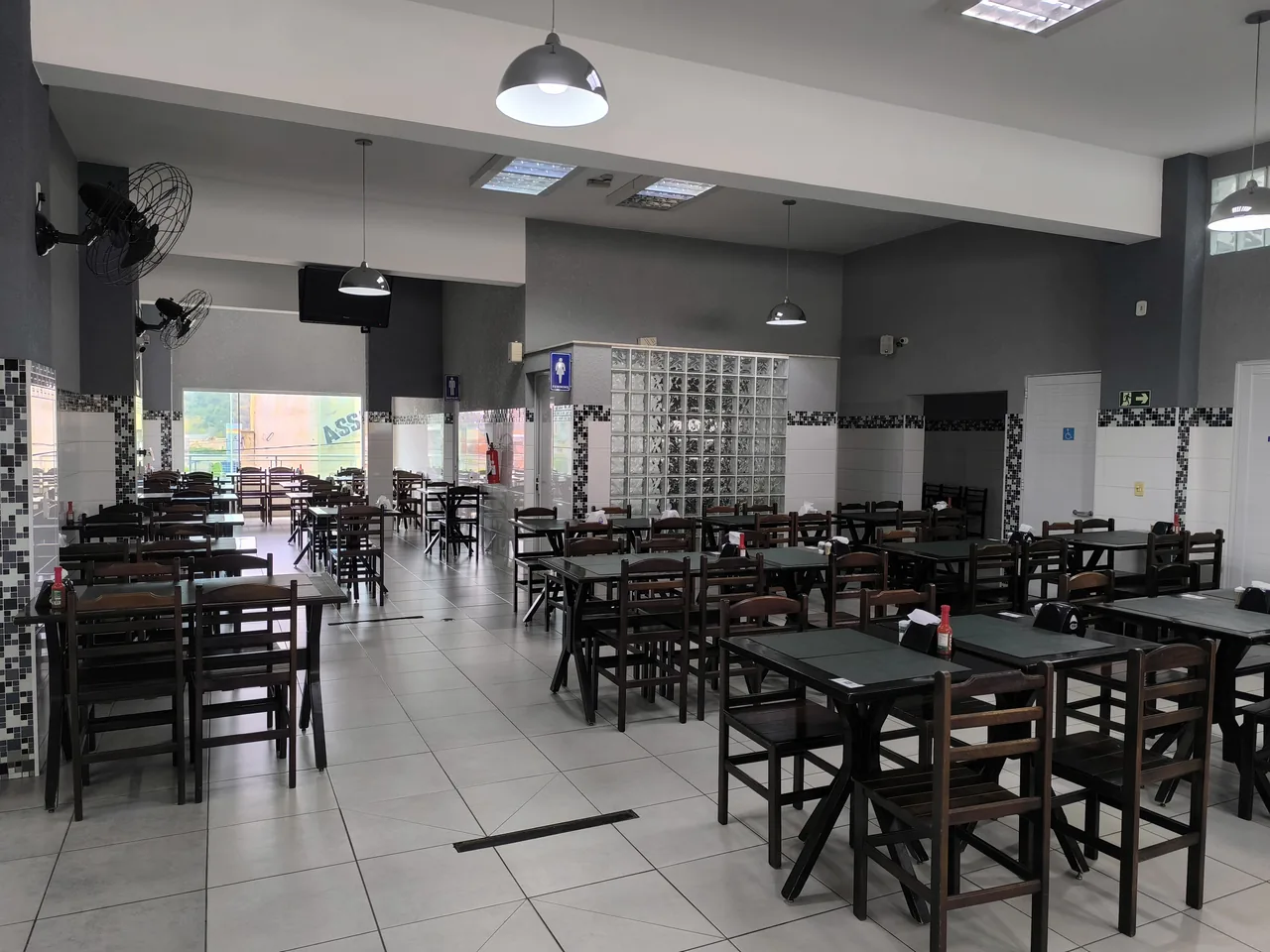 Salão interno do Panelinha Restaurante, com mesas e cadeiras